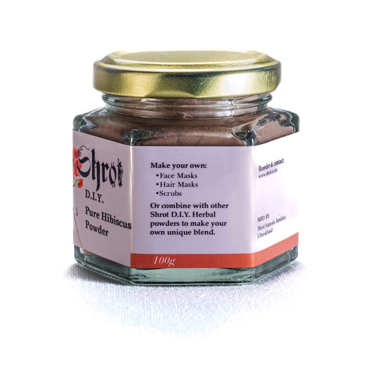 Glass jar of Shrot Hibiscus powder on a white background. Side angle.