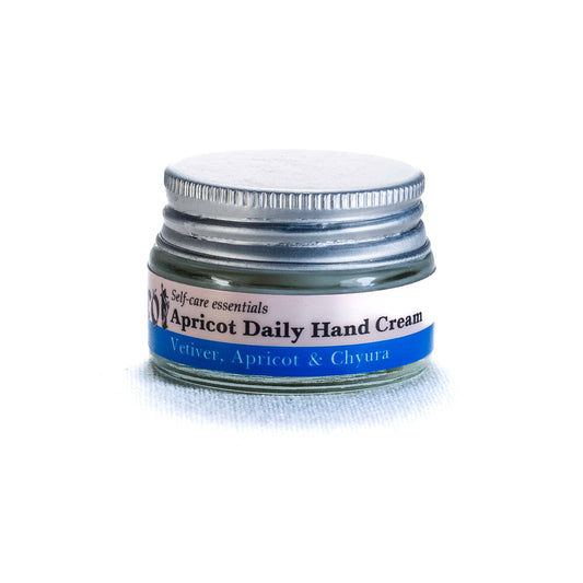 Jar of apricot daily hand cream by Shrot with a silver lid on a white background. Side view.
