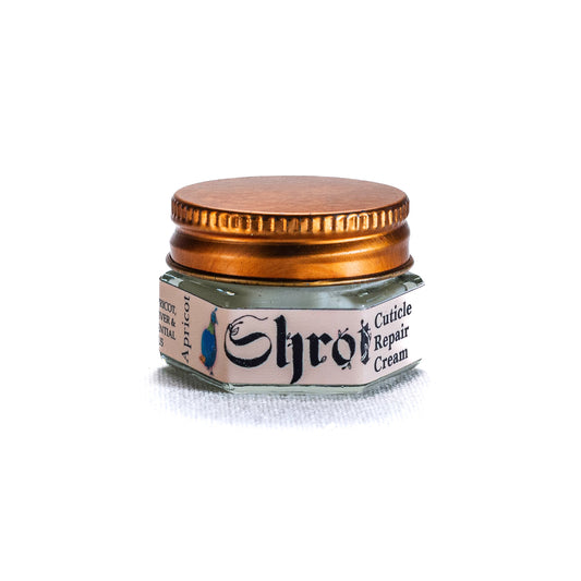 Small jar of Shrot cuticle cream with a gold lid on a white background. front angle.