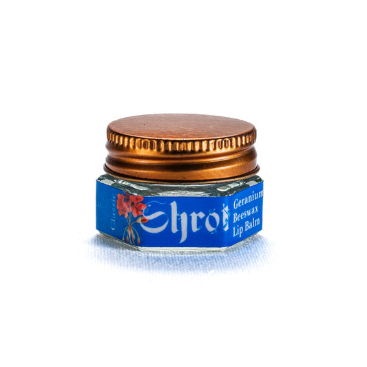 Jar of Shrot lip balm with a gold lid on a white background. front view.