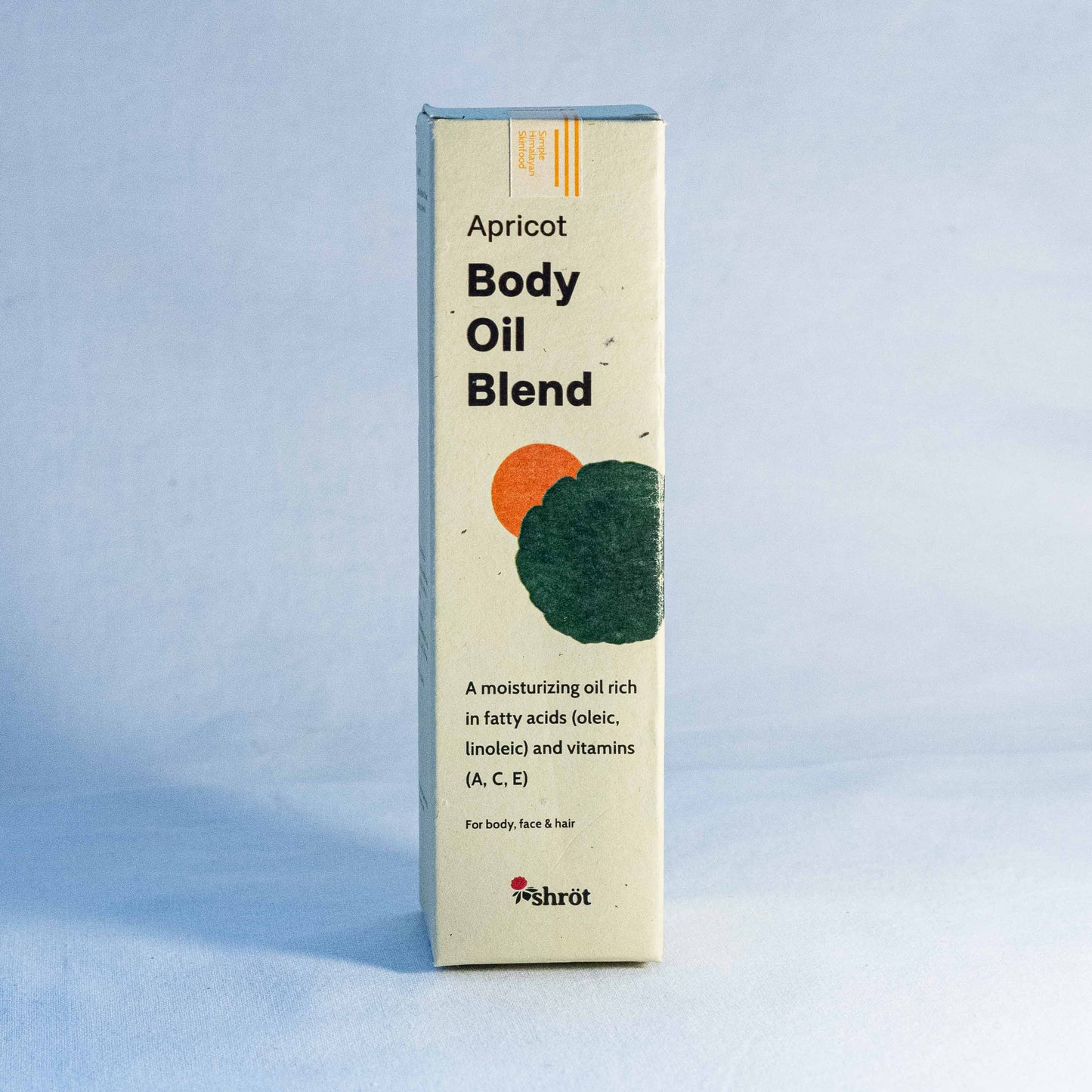 Box of Apricot Body Oil Blend by a natural skincare brand called Shrot on a light blue background