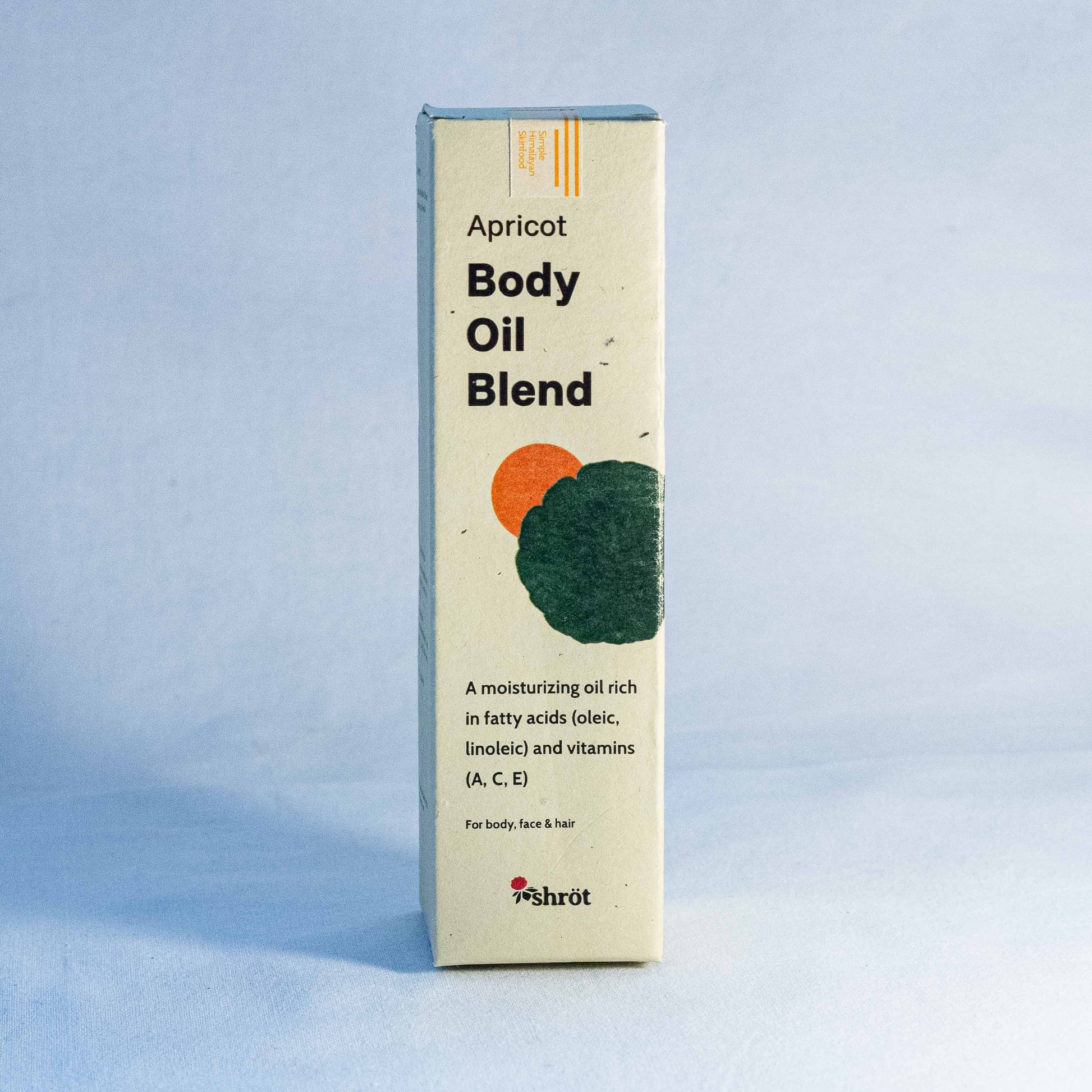 Box of Apricot Body Oil Blend by a natural skincare brand called Shrot on a light blue background