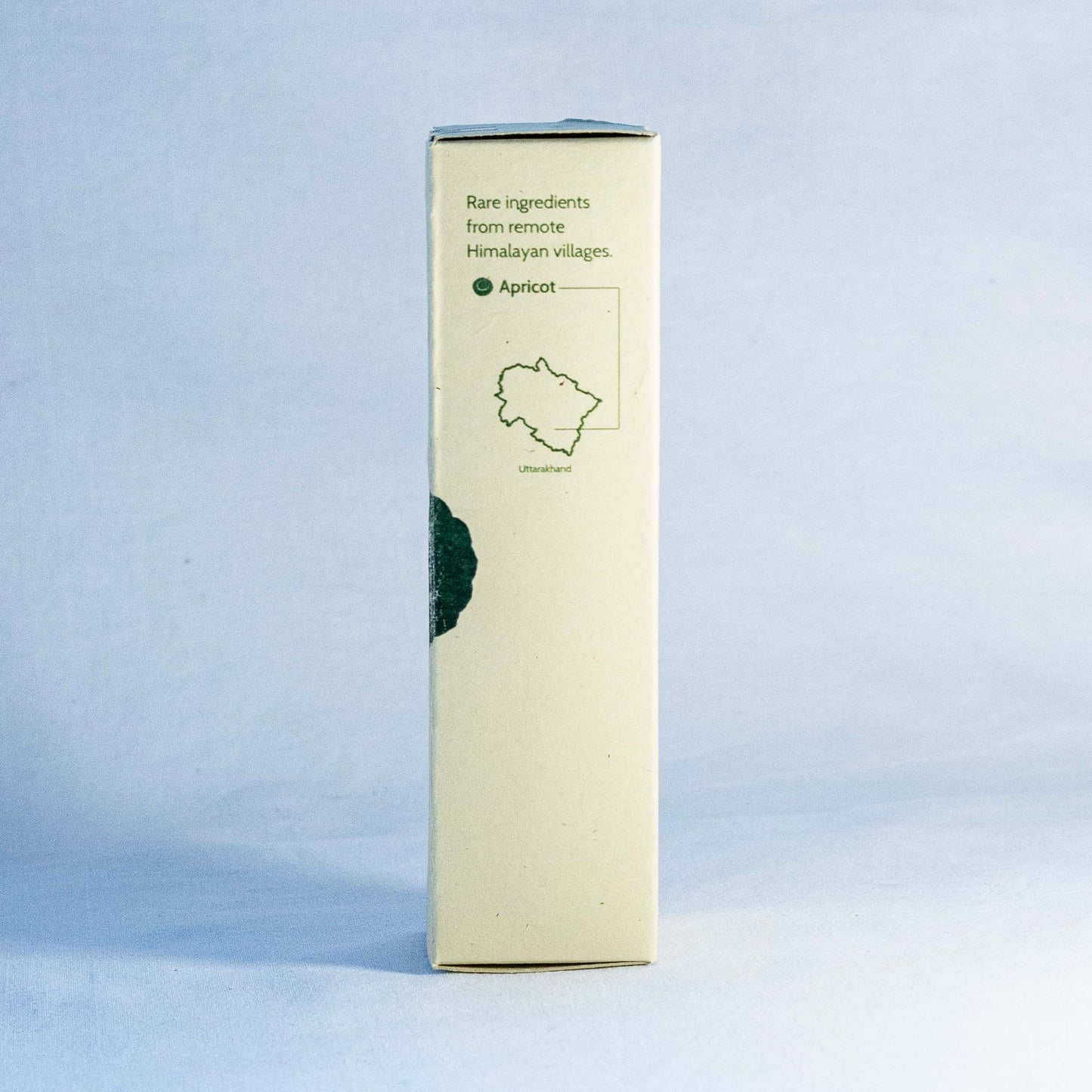 Rectangular box with green text and apricot illustration by a natural skincare brand called Shrot on a light blue background
