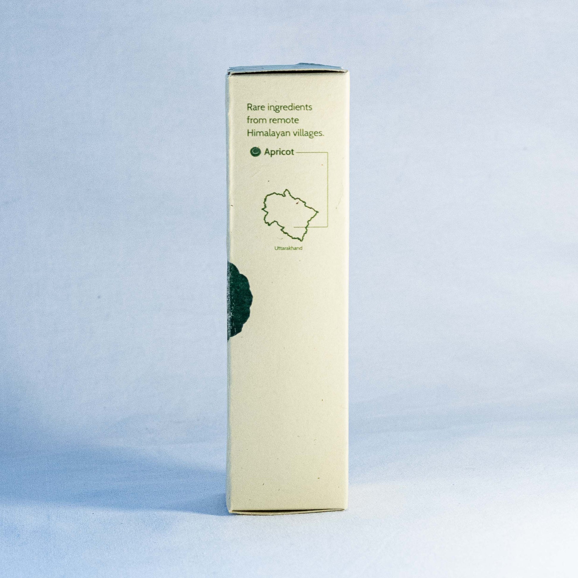 Rectangular box with green text and apricot illustration by a natural skincare brand called Shrot on a light blue background