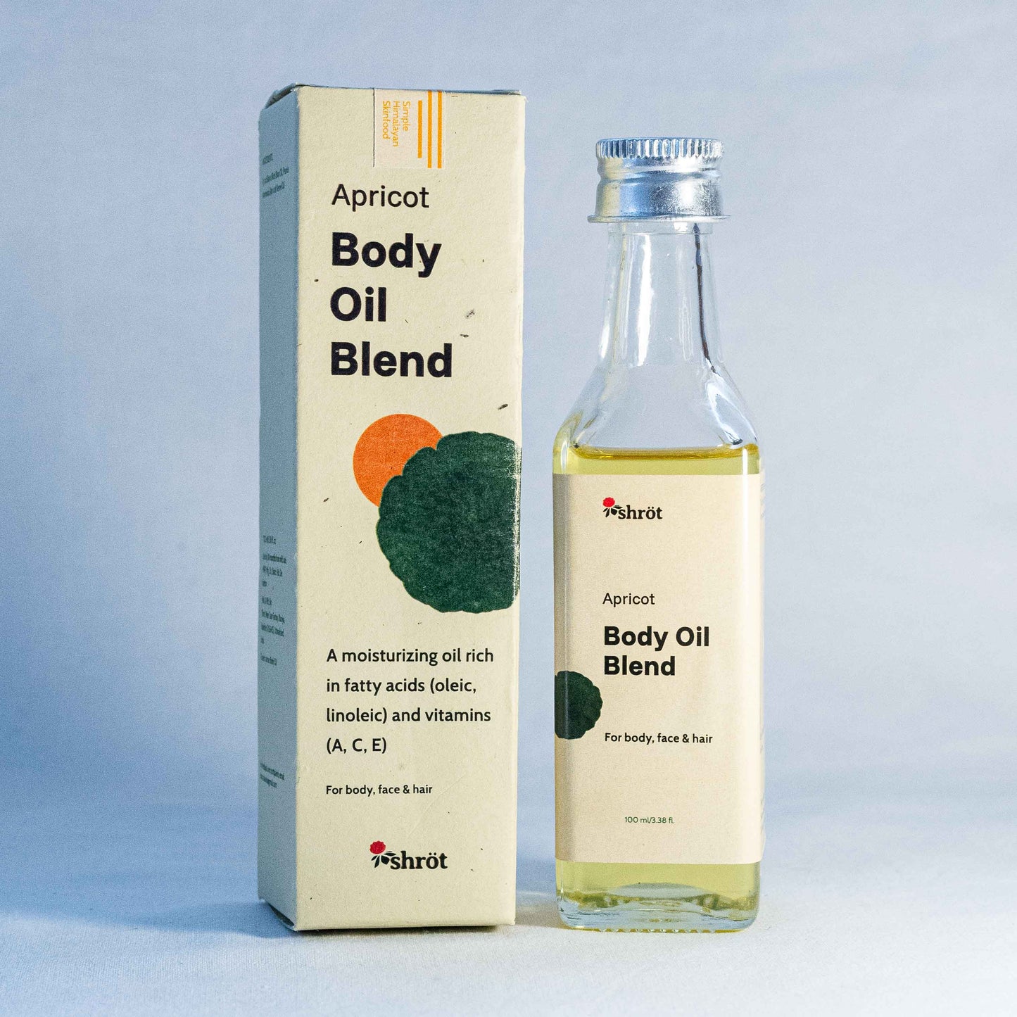 Apricot body oil blend packaging with bottle by a natural skincare brand called Shrot on a light blue background
