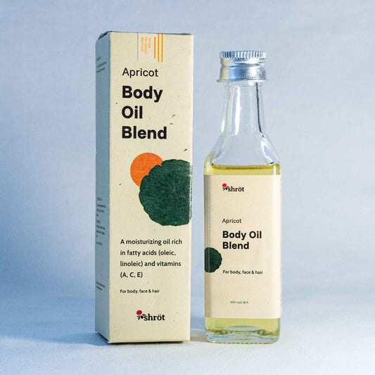 Apricot body oil blend packaging with bottle by a natural skincare brand called Shrot on a light blue background