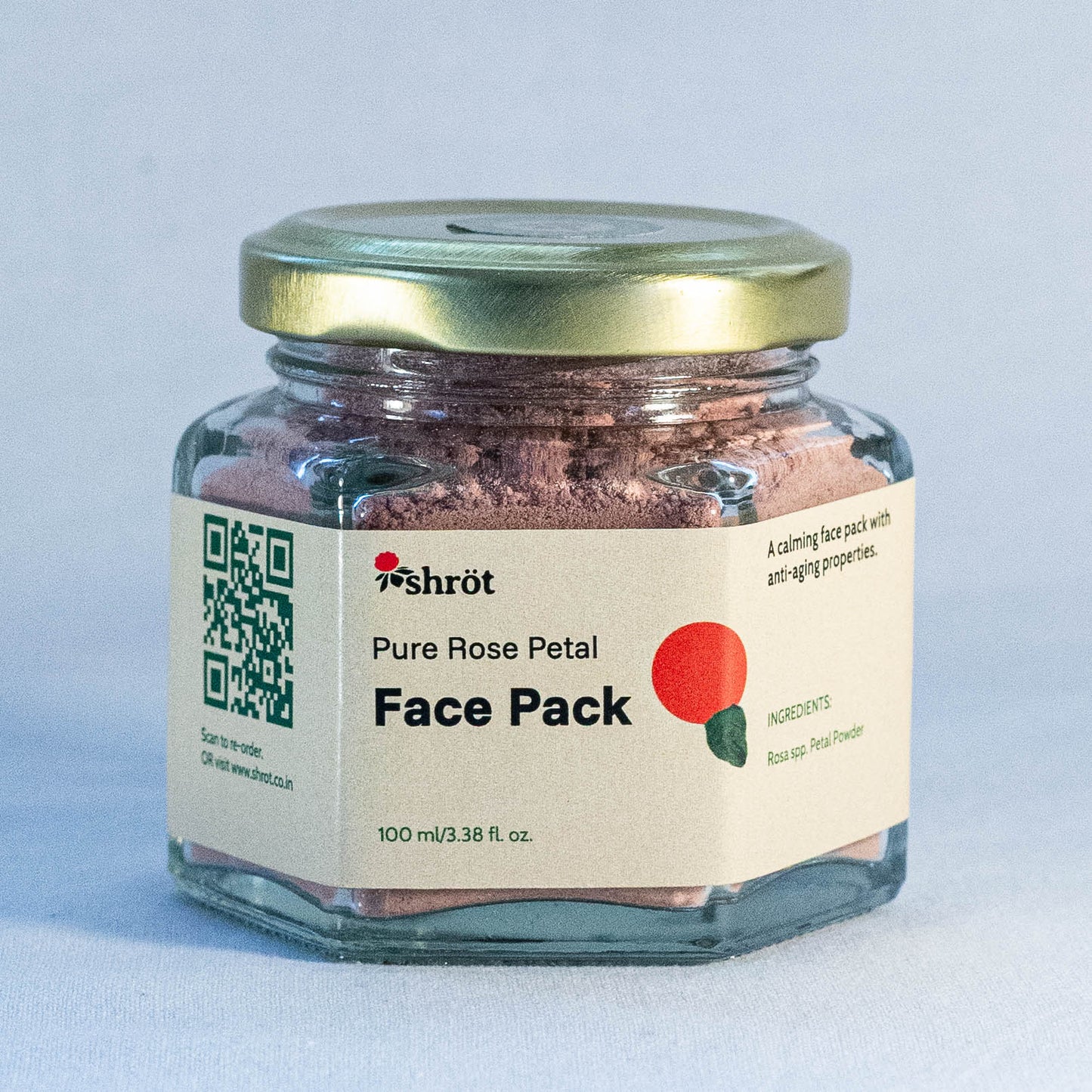 Glass jar of pure rose petal face pack by Shrot natural skincare with a gold lid on a light gray background