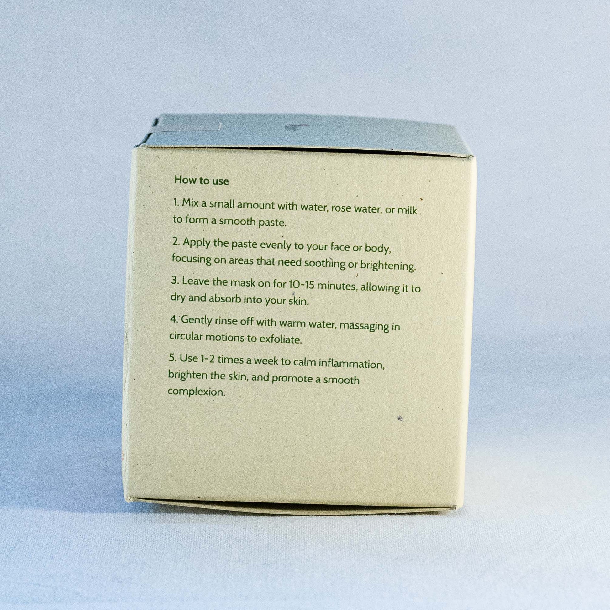 Instructions on how to use a facial mask  by Shrot natural skincare on a cardboard box with a light blue background