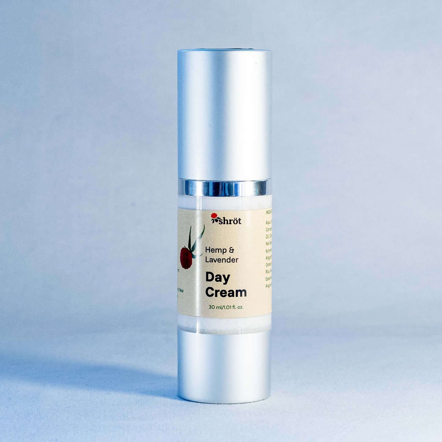 Day cream bottle with silver cap and label by a trending Indian skincare brand called Shrot on a light blue background