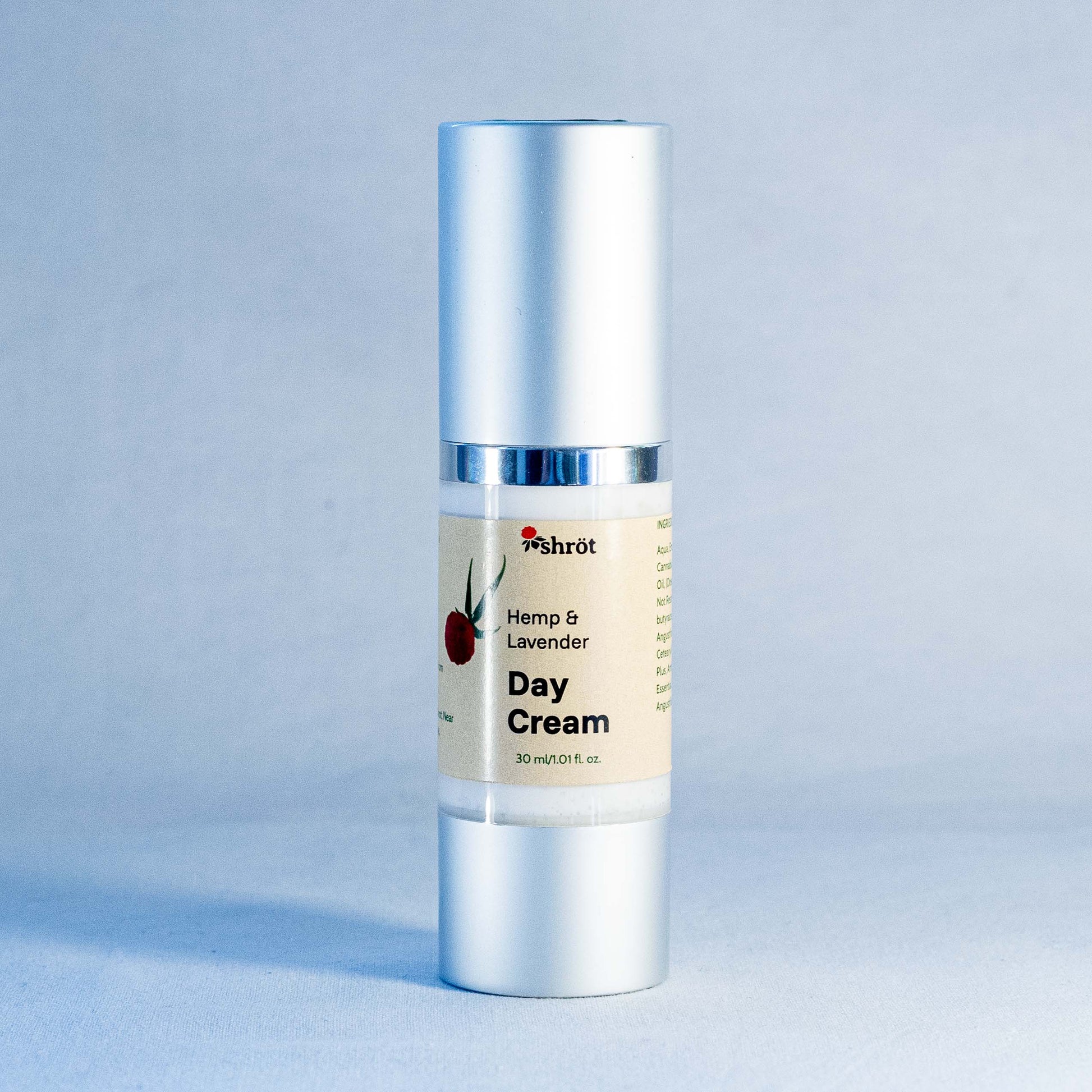 Day cream bottle with silver cap and label by a trending Indian skincare brand called Shrot on a light blue background