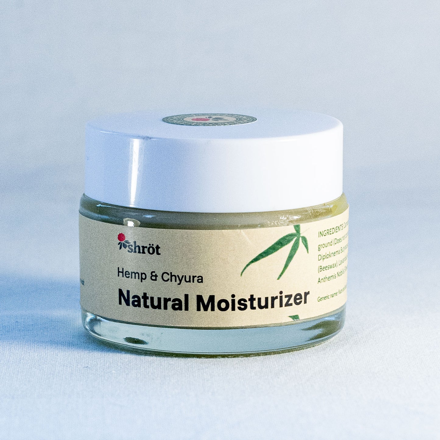 Jar of natural moisturizer with a white lid on a light gray background by a natural skincare brand called Shrot