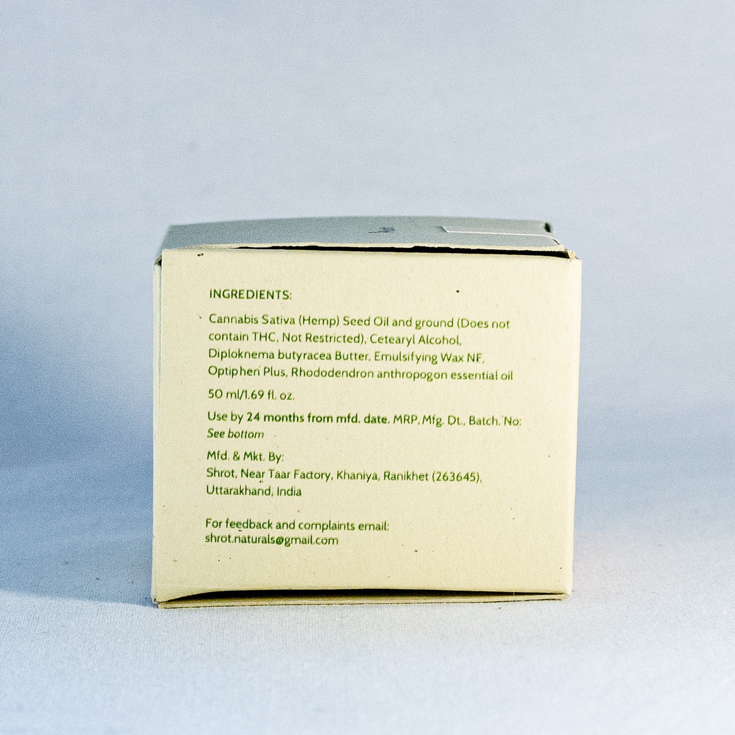 Product packaging with ingredient list and contact information by a natural skincare brand called Shrot on a light gray background