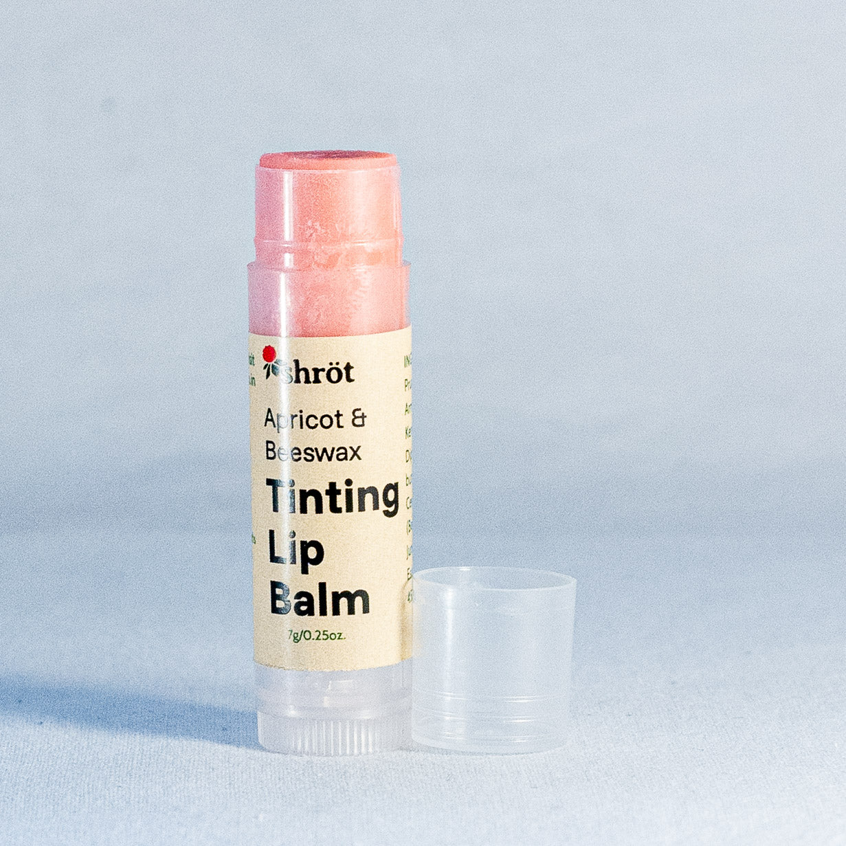 Lip balm with a visible brand label on a light gray background by a natural skincare brand called Shrot.