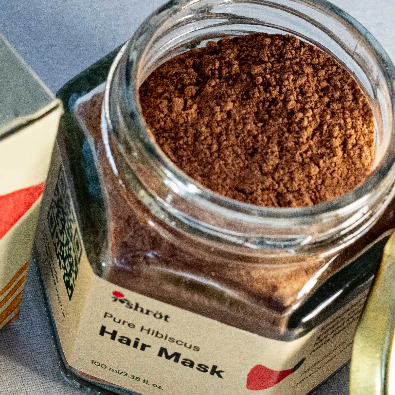 Jar of Shrot Pure Hibiscus Hair Mask with brown powder inside