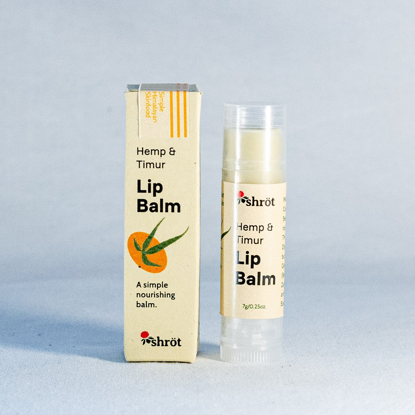 Lip balm with packaging by a natural skincare brand called Shrot on a light gray background
