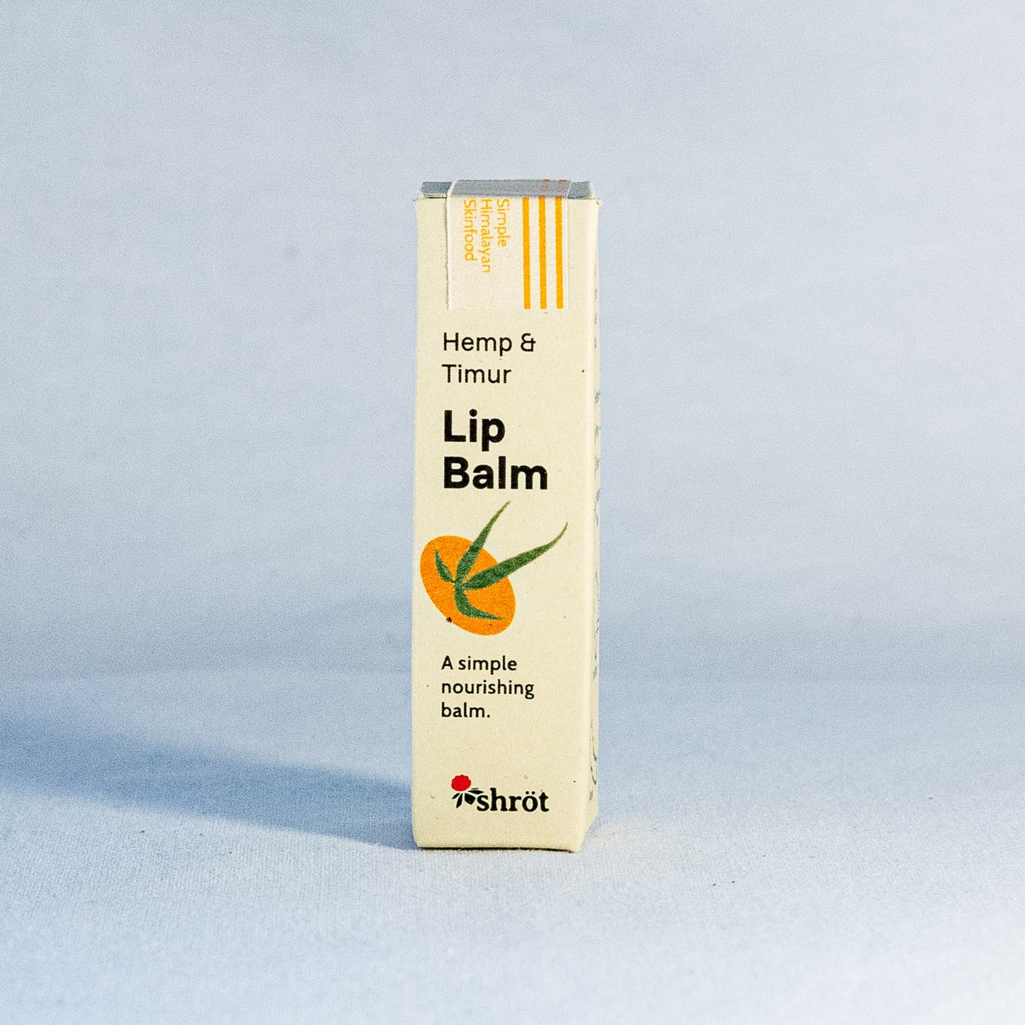 Lip balm packaging with 'Hemp & Timur' branding by a natural skincare brand called Shrot on a light gray background