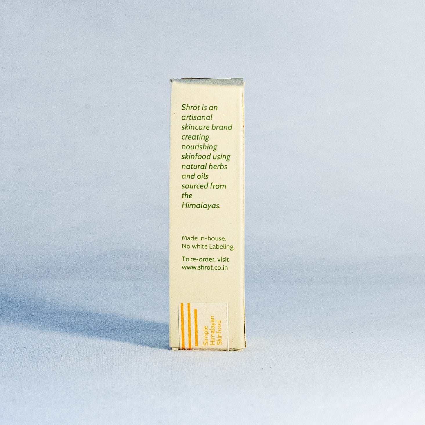 Skincare product box with text by a natural skincare brand called Shrot on a light blue background