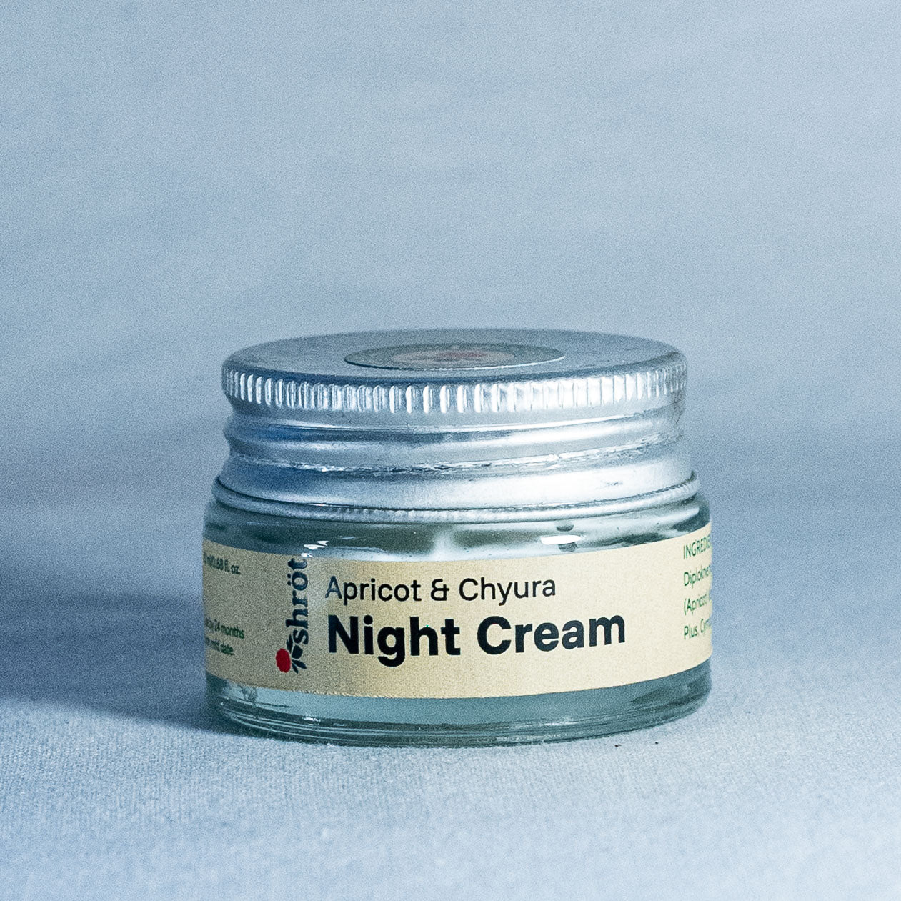 Jar of night cream labeled 'Apricot & Chyura' on a light blue background by a trending Indian skincare brand called Shrot