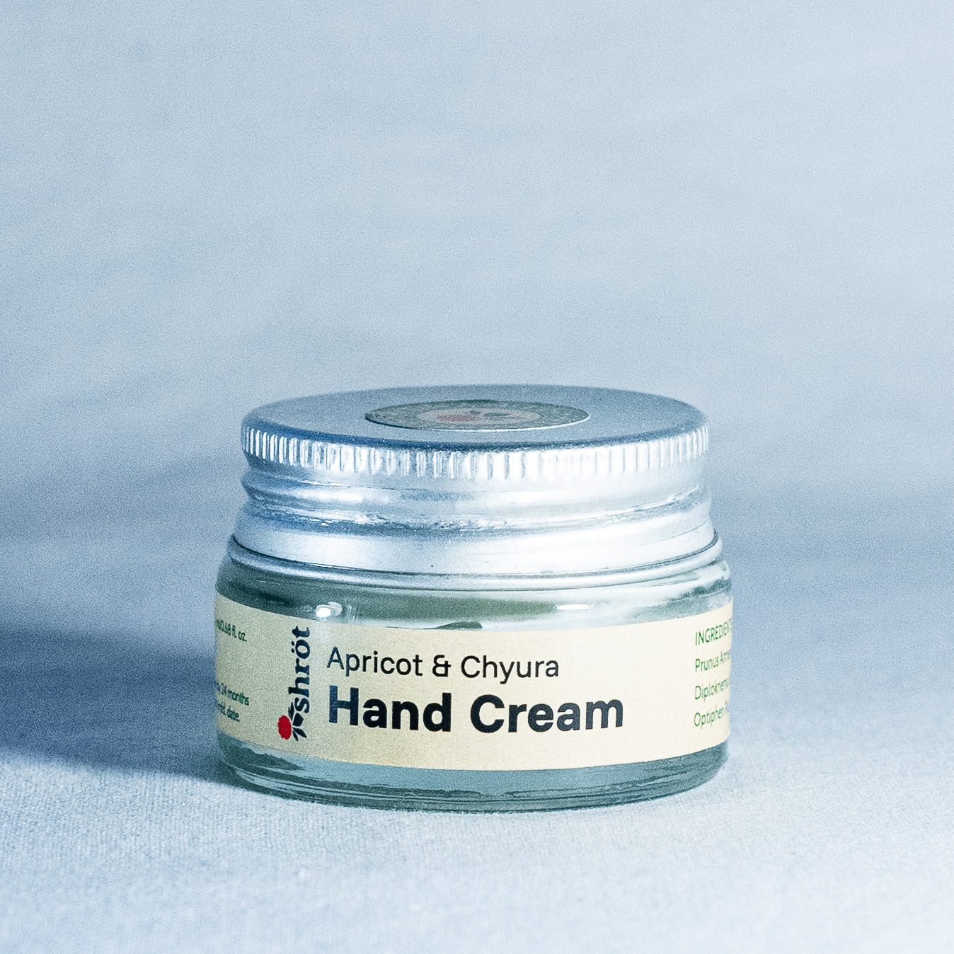 Jar of apricot and chyura hand cream on a light gray background by a trending Indian skincare brand called Shrot 