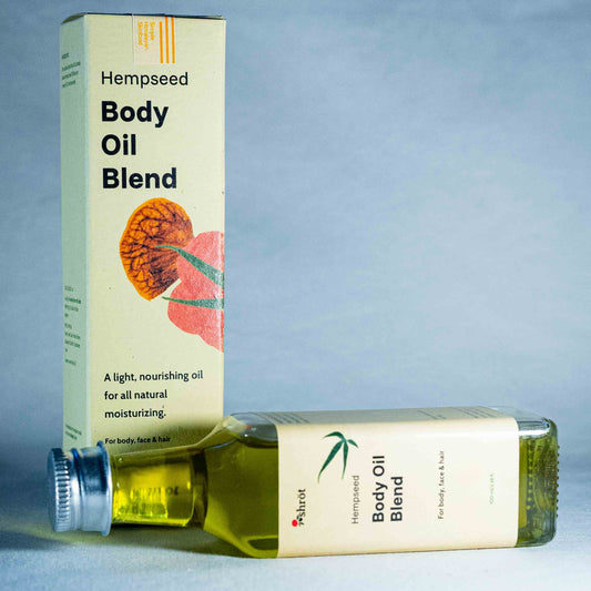 Hempseed Body Oil Blend packaging and bottle by a natural skincare brand called Shrot on a blue fabric background