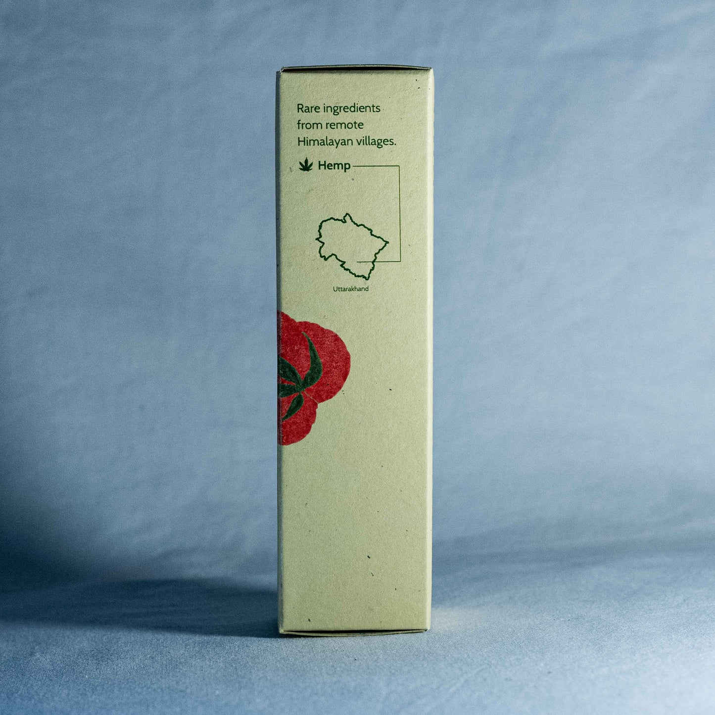 Tall rectangular box with a red floral illustration by a natural skincare brand called Shrot, and text on a gray background