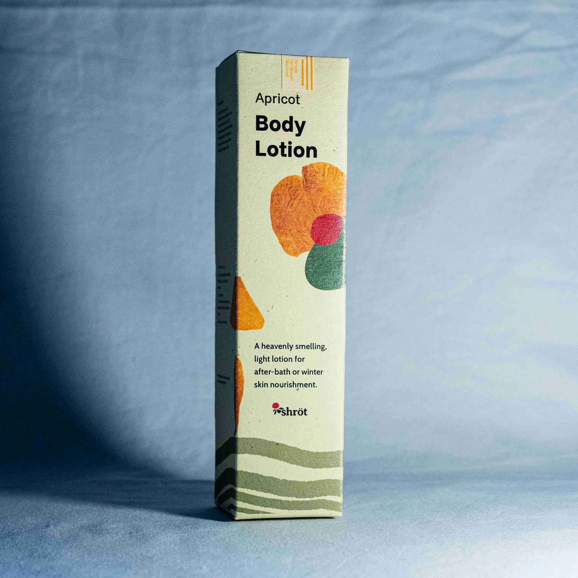 Box of apricot body lotion on a gray background by a trending Indian skincare brand called Shrot