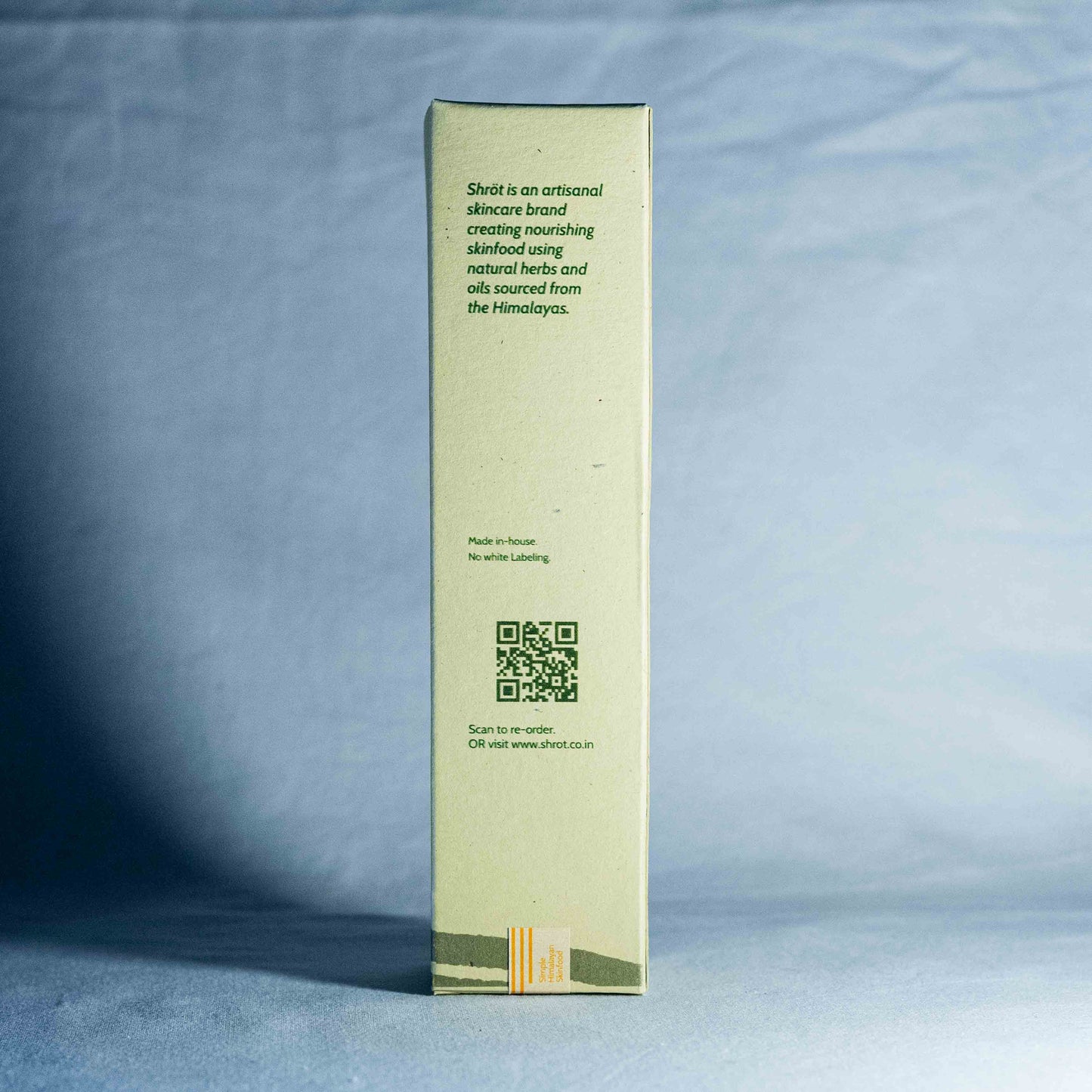 Green skincare product box with text and QR code on a blue background by a trending Indian skincare brand called Shrot