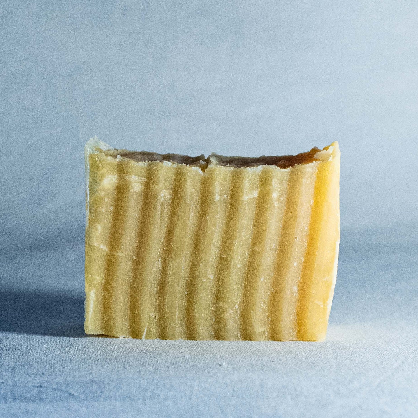 Bar of soap by Shrot with a textured surface on a light blue background