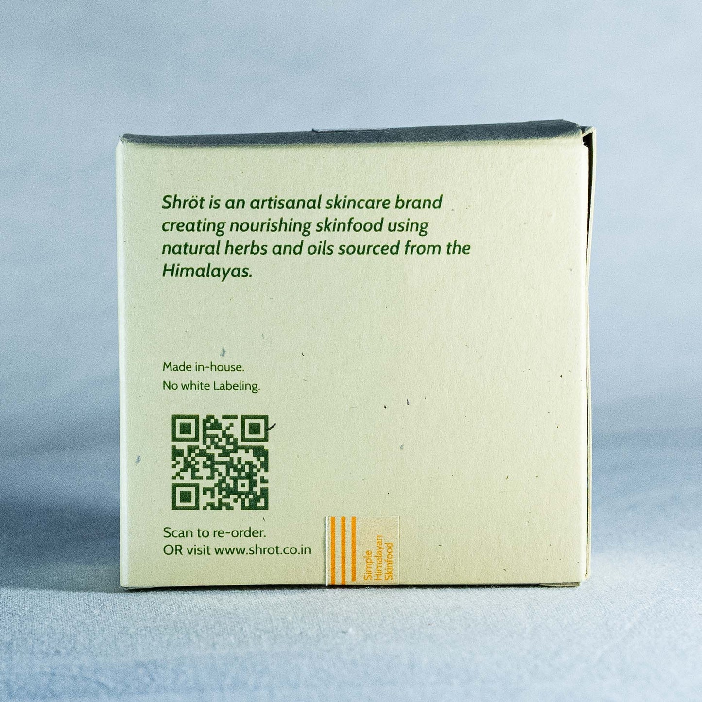 Back of a Shrot skincare product box with branding and contact information on a gray background