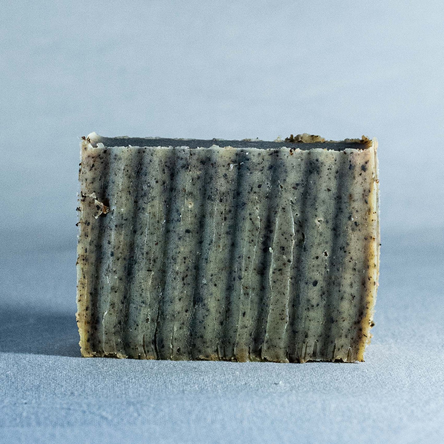 Bar of Natural soap by Shrot with a textured surface on a light blue background